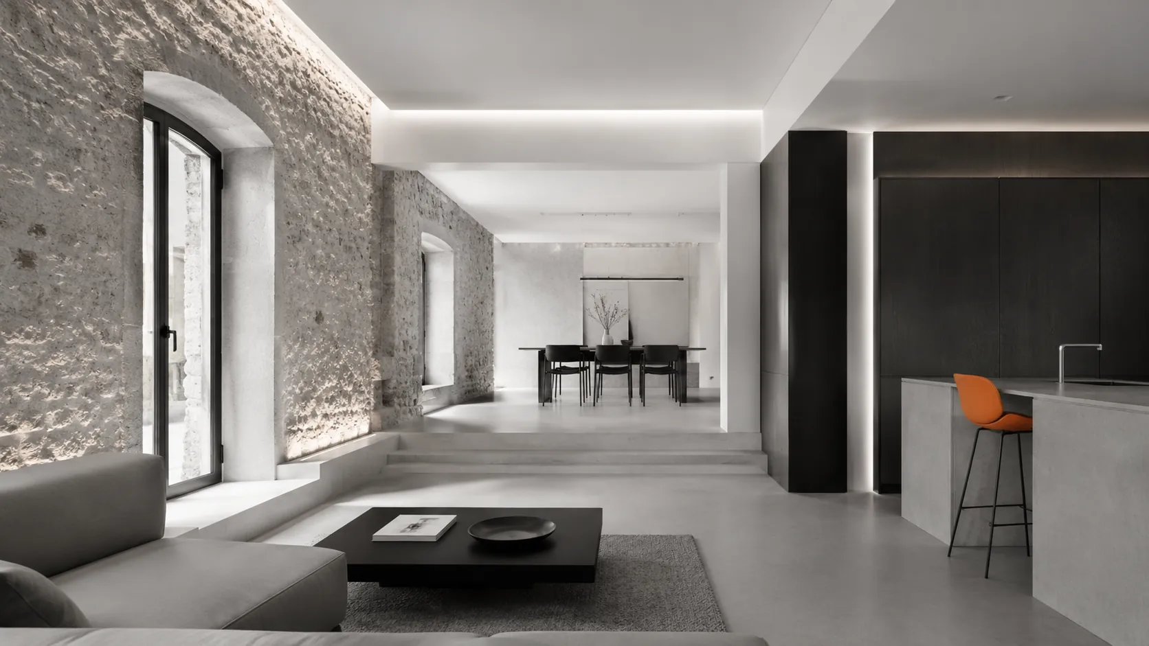 Interior rehabilitado que combina muro de piedra original con acabados contemporáneos.