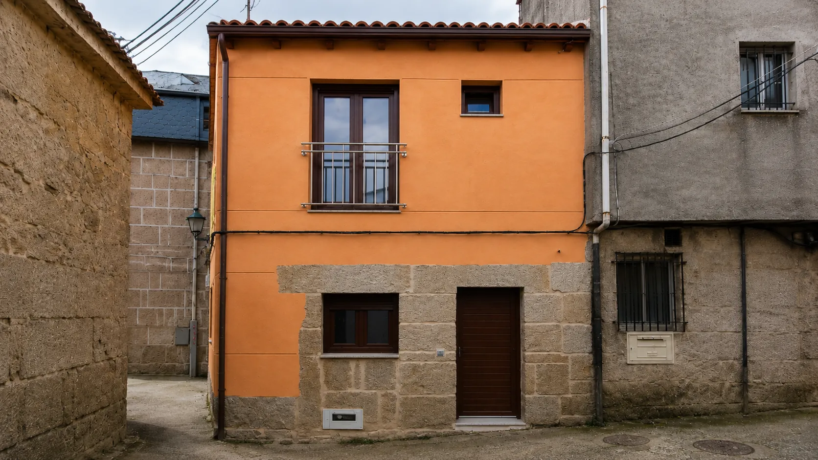 La misma vivienda tras la rehabilitación, con fachada enfoscada y carpinterías nuevas.